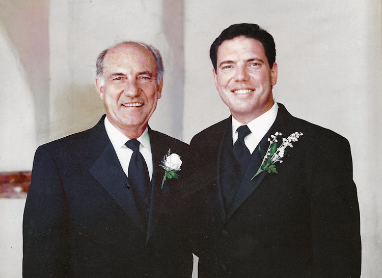 Edward and Mark Silacci, wearing sharp business suits, smile for the camera